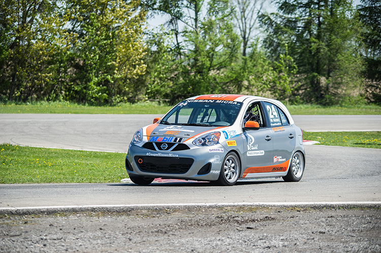 A Nissan Micra Cup car driving on a track at Calabogie Motorsports Park.