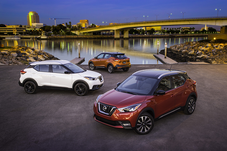 The affordable 2019 Nissan Kicks, a compact crossover, is parked in front of a bridge.