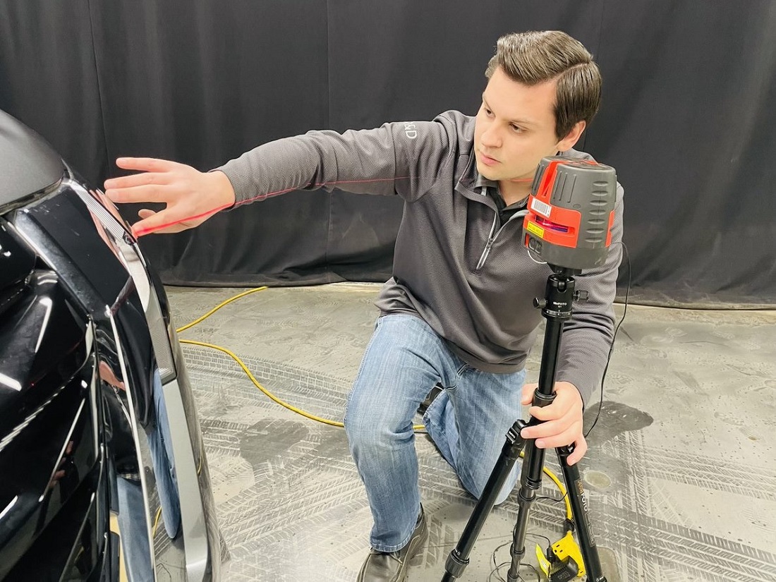 Kyle Martus using equipment to check vehicle headlamp lighting