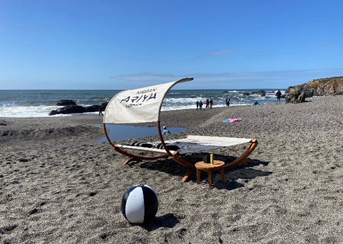 A beach chair on the sand next to a ball in Canada.