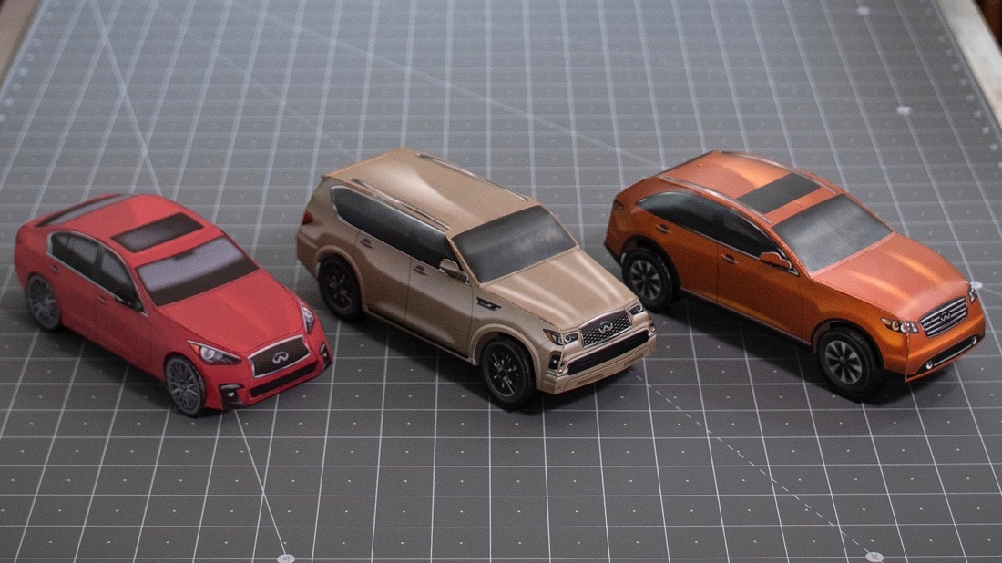 3 little paper cars set on a cutting board
