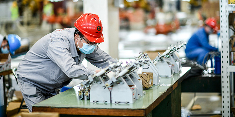 Plant workers in China working on mask-manufacturing machines